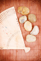 Oriental Fan with Rocks on Bamboo Background