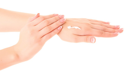 Closeup of beautiful female hands applying hand cream  on white