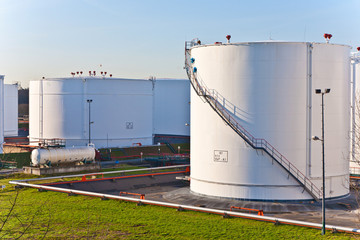 white tanks in tank farm with blue sky