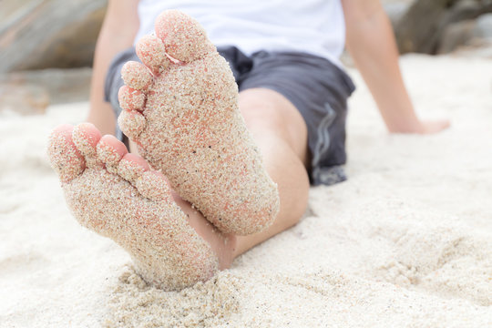 feets of a man which are covered with sand