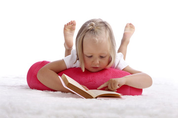 little girl reading a book on the floor