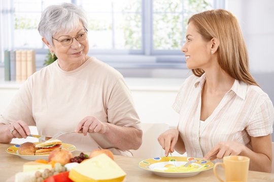 Young woman having lunch with mother smiling