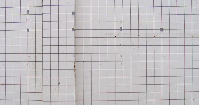 old wall with square worn ceramic white tiles