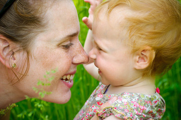 Portrait of mother and her little baby playing - outdoors
