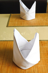 white napkins folded as triangles on the table