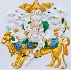 Four heads ganesha riding lion on white wall