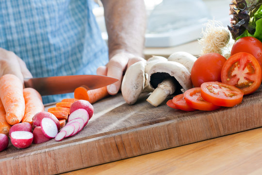 Man Cutting Vegetables On A Chopping Board