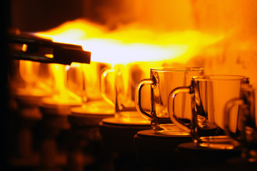 Glass cups in the fire on the conveyor