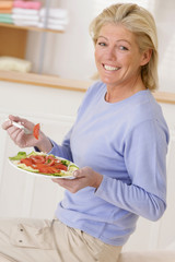 Femme senior avec une assiette de crudités