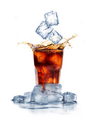 Cola with ice cubes splashing