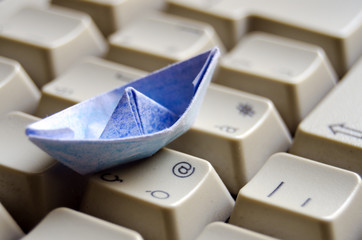 Blue boat on keyboard -Travel or navigating Internet concept