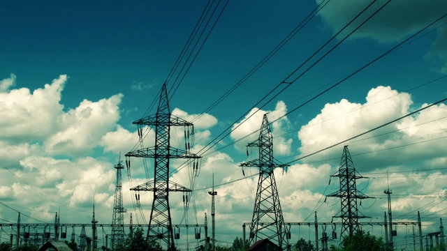 electric high voltage pylon against sky, time lapse