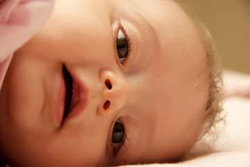 bambina coricata nel lettino sorride