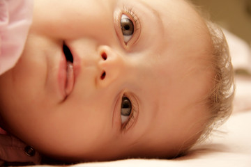 bambina coricata nel lettino sorride