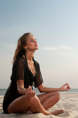 Fototapeta na wymiar young woman sitting on a beach