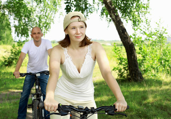 Obraz premium Young couple on the bikes in the park