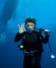 Woman scuba diver under boat