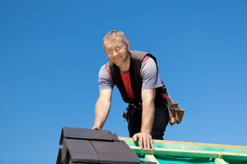 dachdecker legt dachpfannen