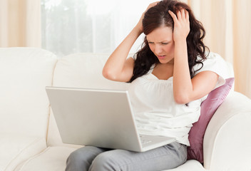 Red-haired woman with laptop being frustrated