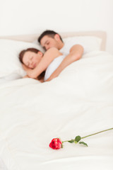 Obraz na płótnie Canvas Rose on a bed of sleeping happy couple