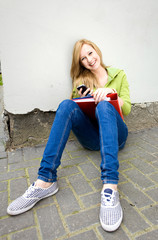 Female student sitting by the wall