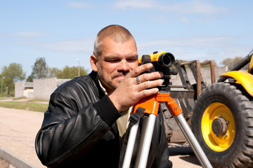 Theodolite on a tripod with construction worker