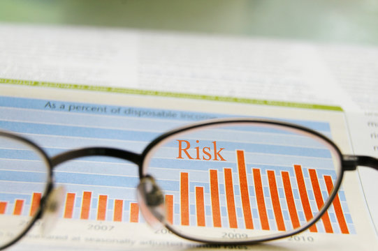 glasses and stock chart showing risk