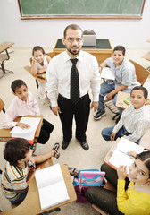 Teacher with children in classroom, boys and girls in school