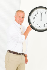 Punctual businessman mature point at clock