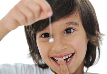 Lost milk-tooth, cute boy holding his tooth on thread