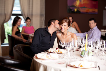 happy couple at restaurant table kissing
