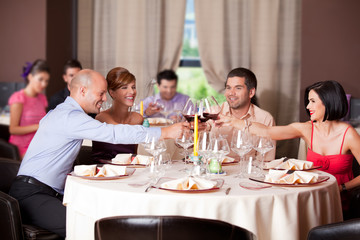 young people toasting restaurant table