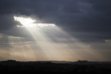 Naklejka na ściany i meble Sunlight przedzierając się przez gęstą zasłonę chmur