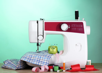 sewing machine and fabric on green background