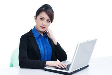Cute young businesswoman using laptop