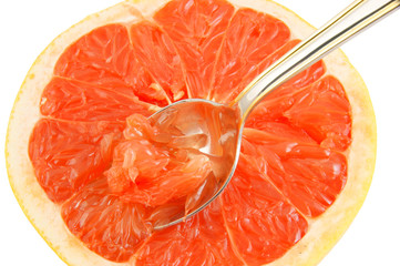 Halved red grapefruit with spoon isolated on white