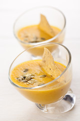 Pumpkin soup in glass plates on white background