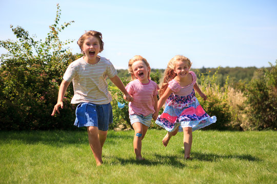 three girls running outdoor laughing