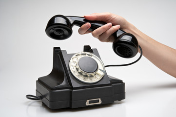 Vintage telephone being picked up
