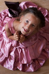 Obraz na płótnie Canvas Smiling cute little girl in a pink dress festive
