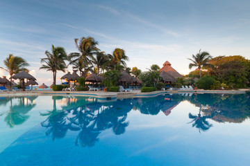 Tropical swimming pool at sunrise in Mexico