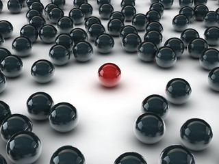 One unique red ball, among other black