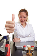 Managerin im Büro hält Daumen nach oben