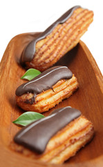 Eclairs on wooden plate