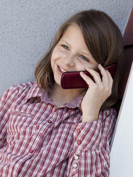enfant souriante au t&eacute;l&eacute;phone
