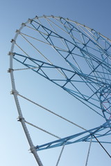 Ferris wheel against a blue sky in the amusement park