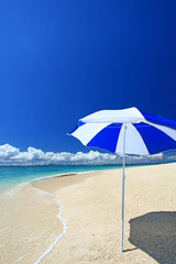 水納島の真っ白い砂浜に立つビーチパラソル