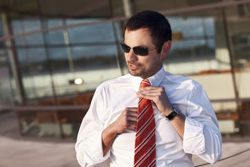 Business person adjusting tie.