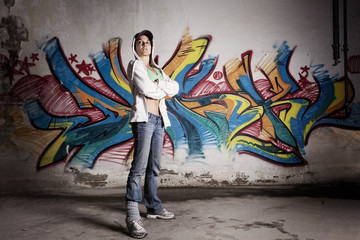Obraz na płótnie Canvas Cool girl standing in front of graffiti.