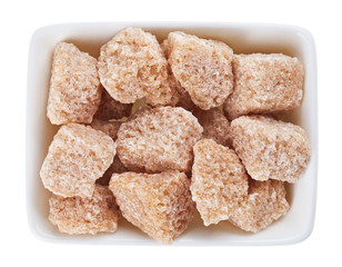 Brown lump cane sugar in a rectangular sugar-basin, isolated on
